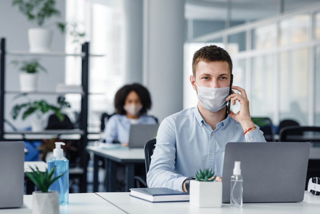 people at desks in masks