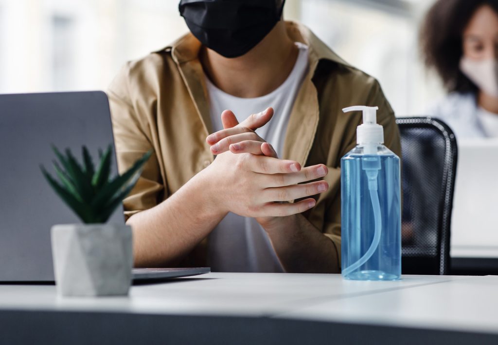 Man at work with mask and sanitizer