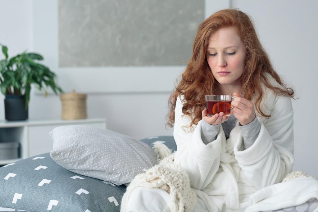 Woman home sick sipping tea