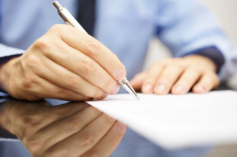 man signing document