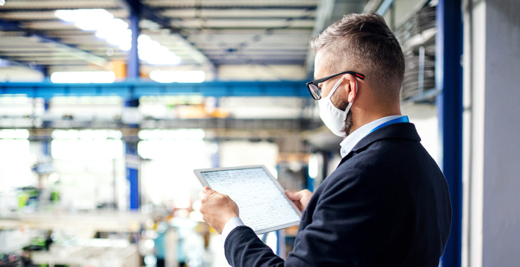 man at factory looking at tablet