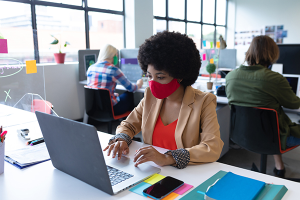 woman in red mask working at computer