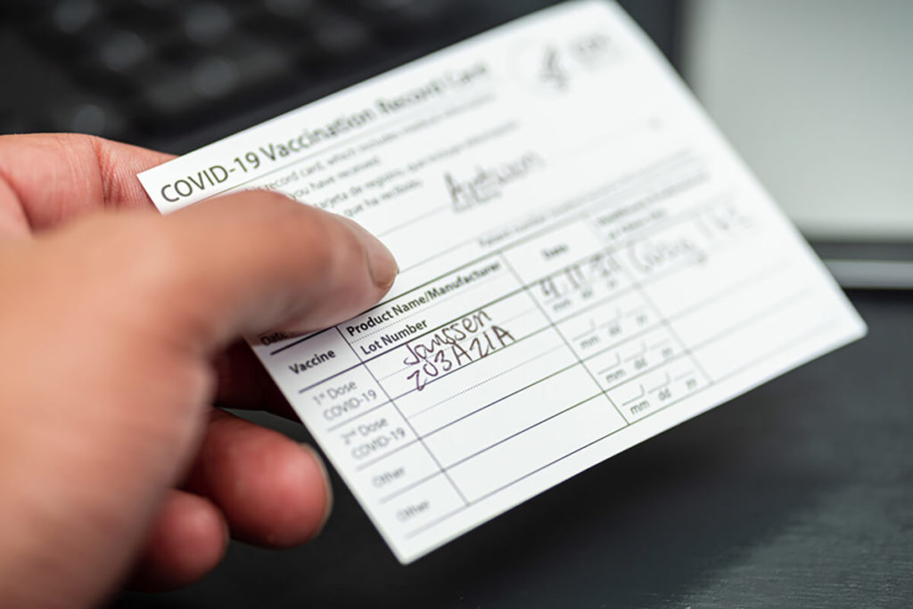 Close up of hand holidng COVID vaccination card