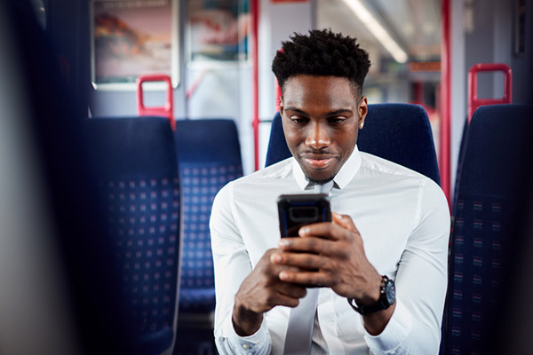 Business man checking phone while on the train