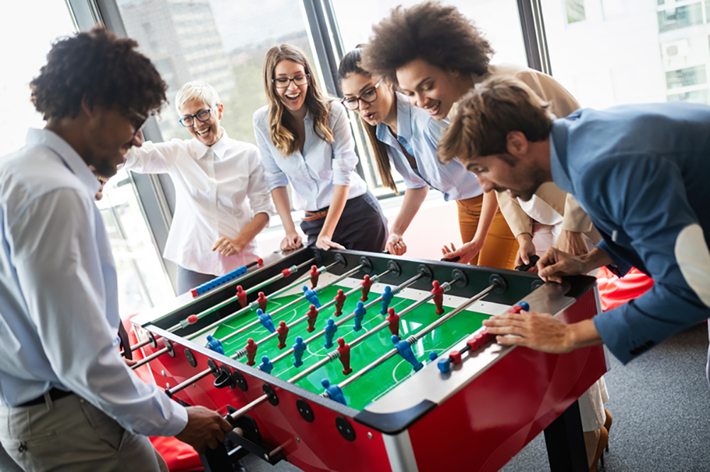 coworkers playing foosball