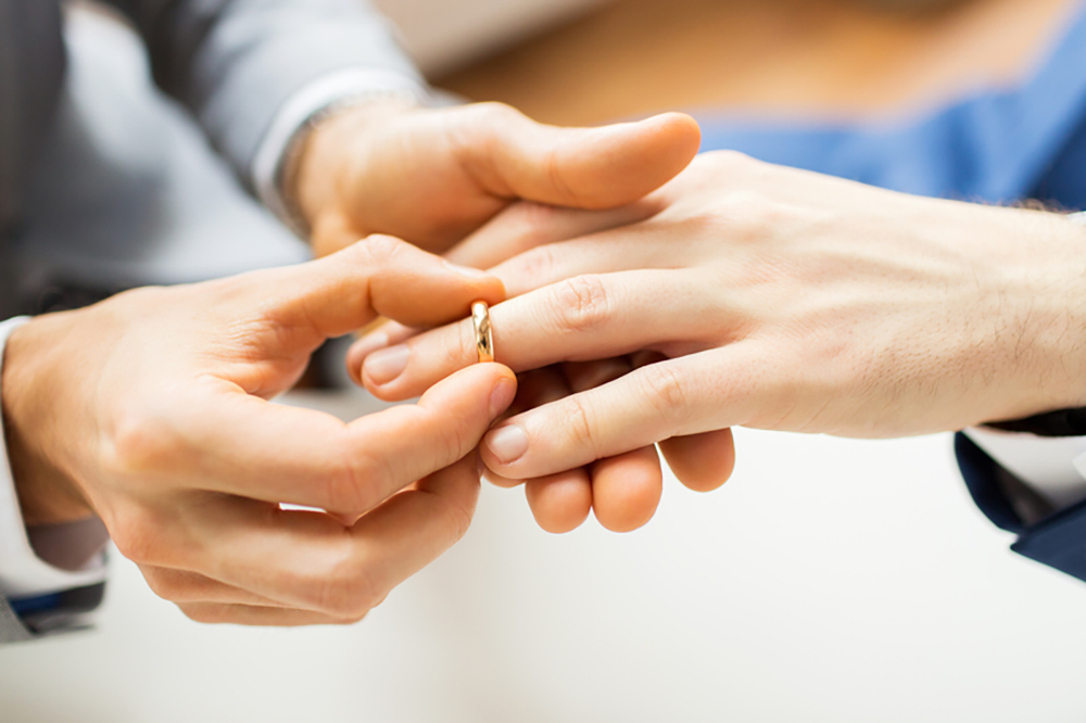 couple putting on ring during marriage ceremony