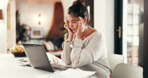 woman home sick from work in front of laptop