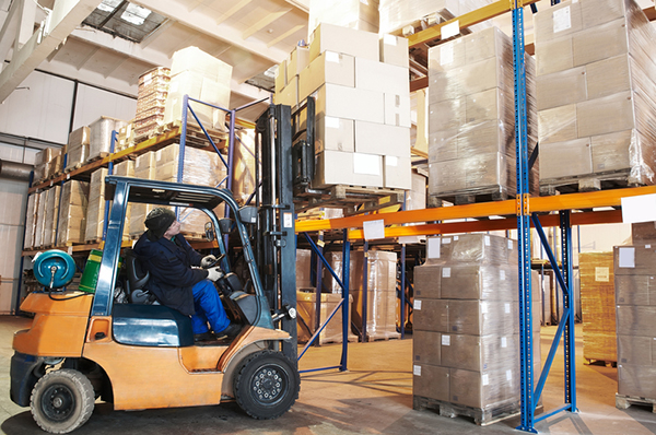 worker with a forklift getting boxes in a warehouse
