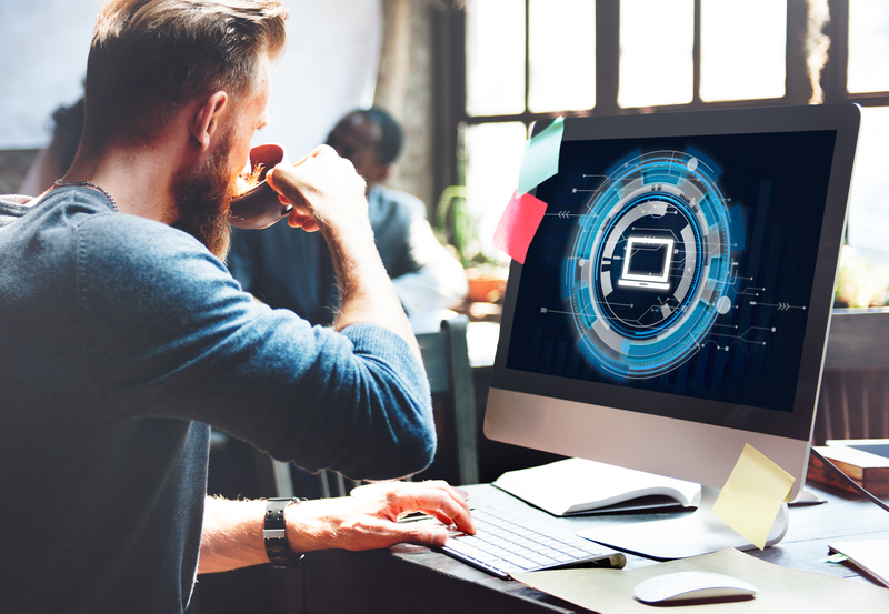 man looking at computer with tech related image